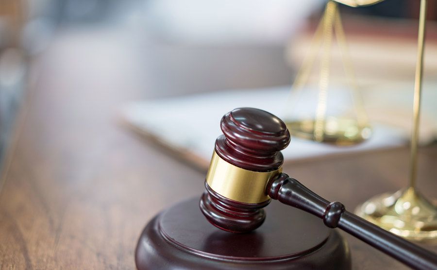 An image of justice scales and books and wooden gavel.