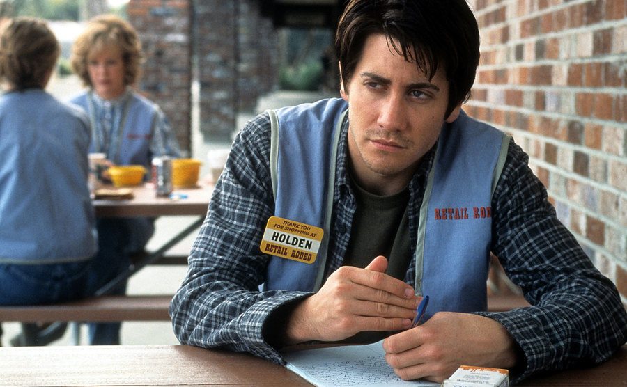 Jake Gyllenhaal is taking notes at a table in a scene from the film 'The Good Girl’.