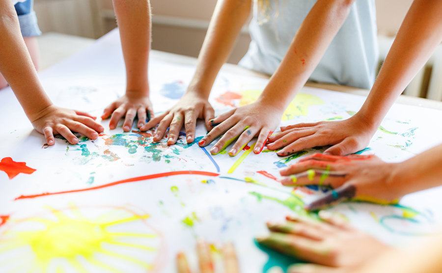 A close-up of children's hands playing whit colors.
