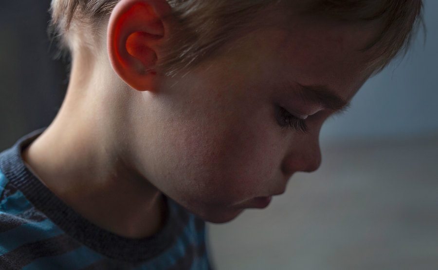 An image of a kid wearing a sad expression on his face.