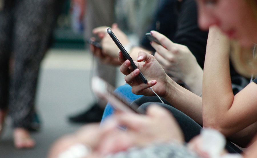 A picture of various people using their phones.