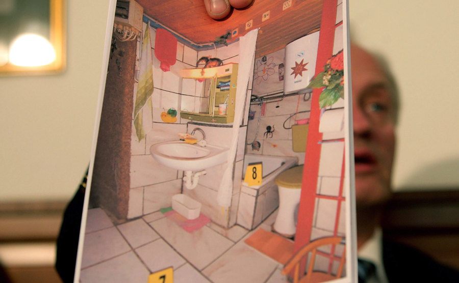 A chief investigator shows a detailed picture of the cellar appartement.