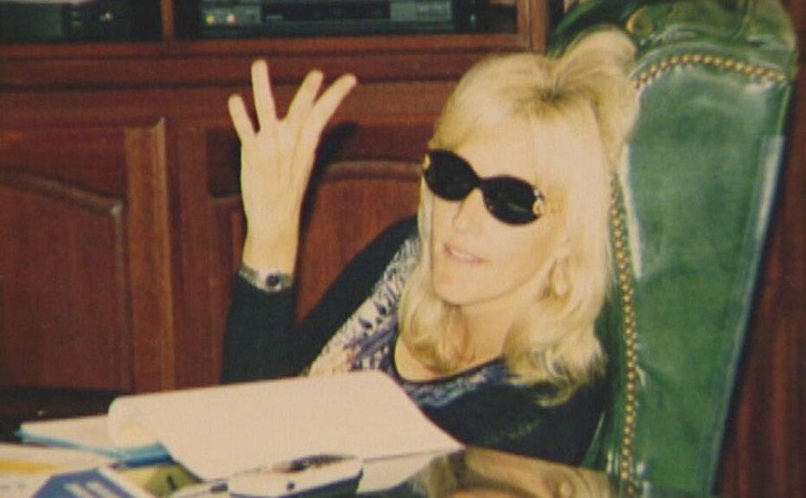 A portrait of Erin Brockovich sitting behind her desk.