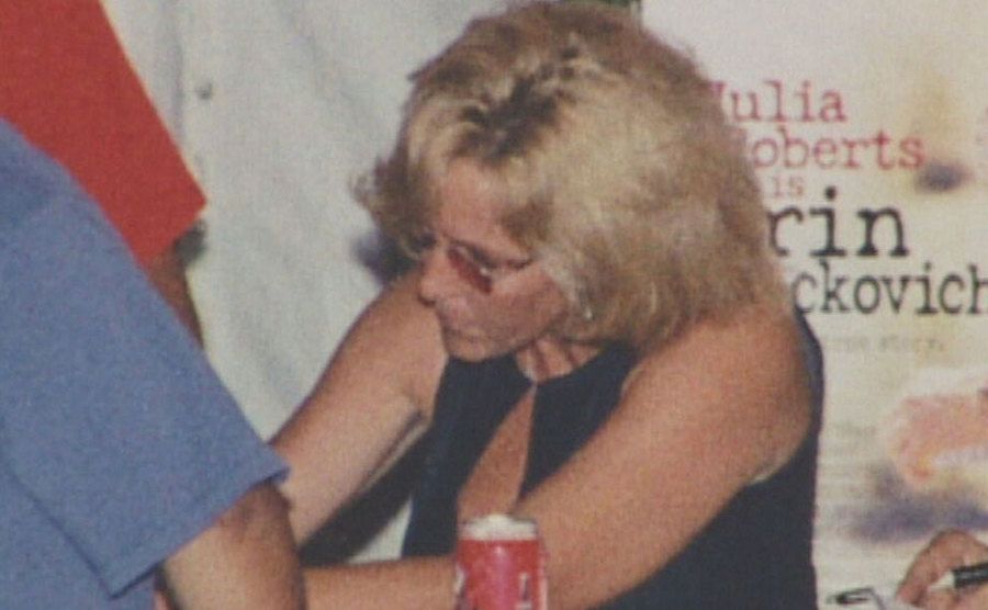 A photo of Erin signing autographs during an event.