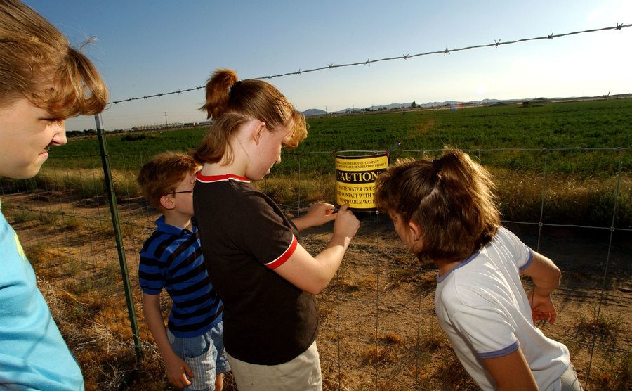 A group of kids read a small sign warning of “nonpotable water.”