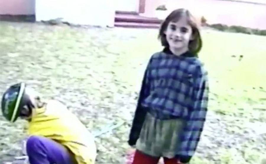 A dated video still of Maddie Clifton playing in her backyard.