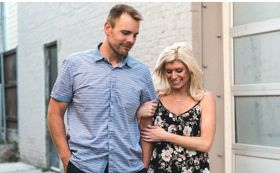 Dave Flaherty and Amber Martorana walk down the street holding hands.