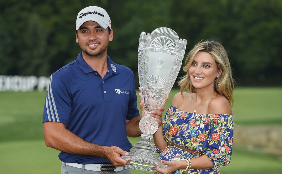 Jason Day poses with the winner's trophy alongside his wife Ellie.