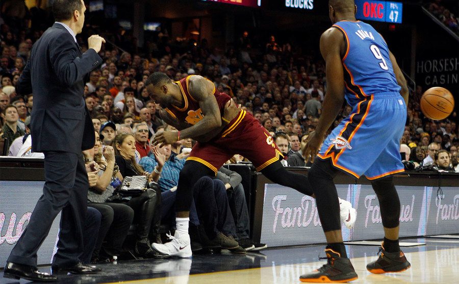 LeBron James crashes into the stands in pursuit of a loose ball.
