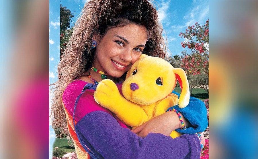 Mila Kunis hugs a Lisa Frank doll.