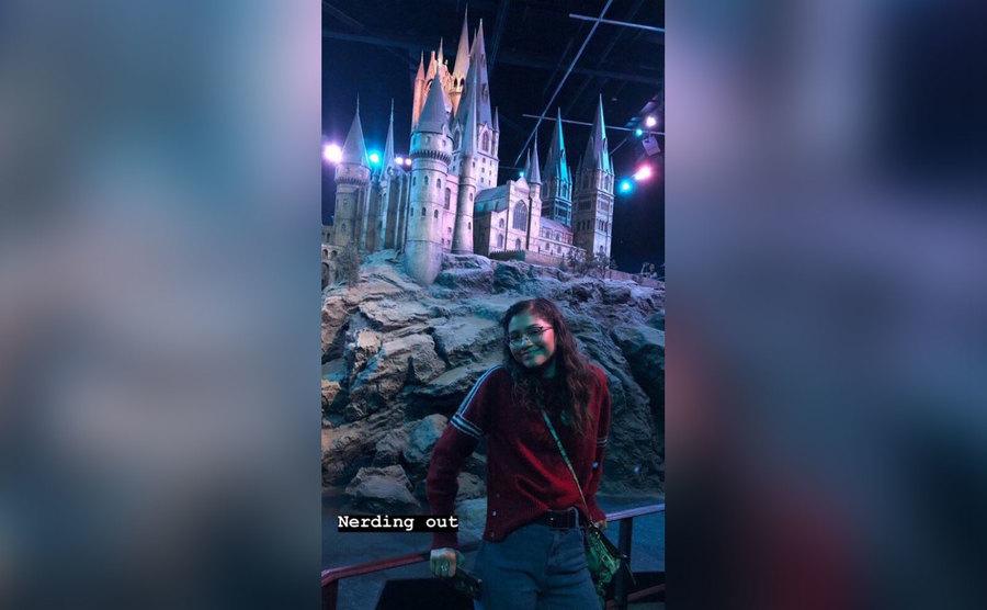Zandya poses in front of a miniature Hogwarts Castle.