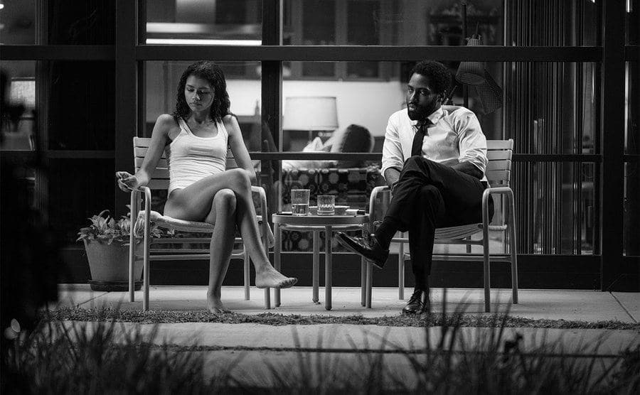 Zendaya and John David Washington sit on the patio in a scene from the film.