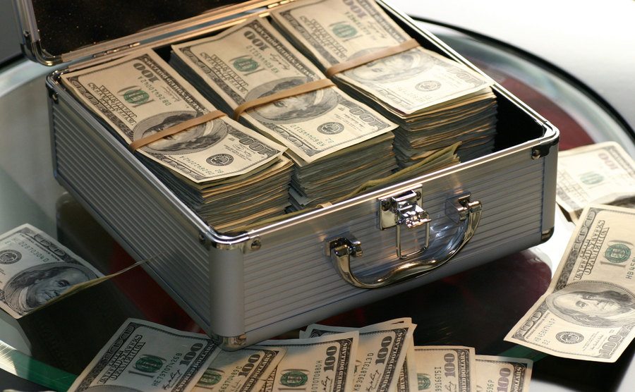 A picture of dollar bills inside a suitcase. 