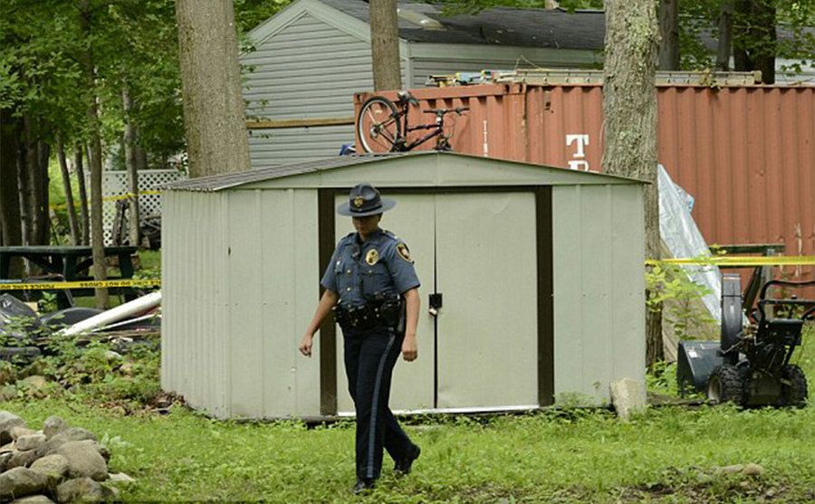 An officer searches the area where Abby was held captive.