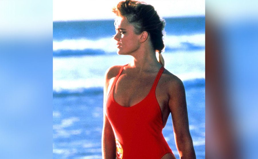 Erika Eleniak, as Shauni McClain, walks along the beach.