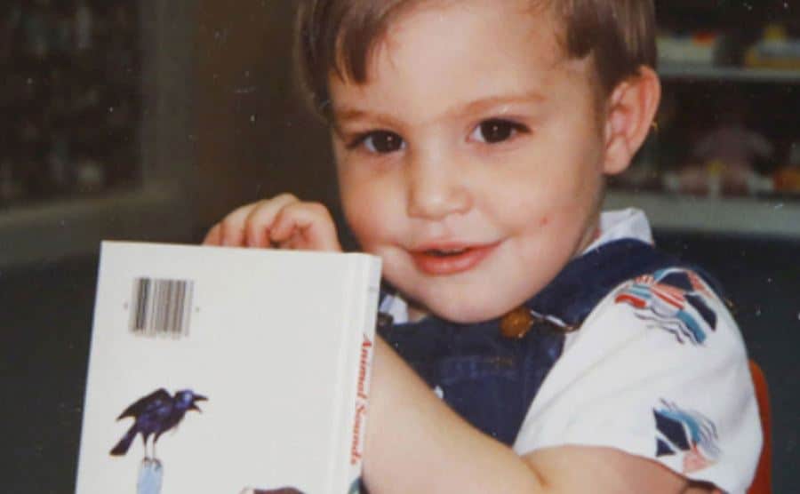 A dated picture of Michael playing with a book.