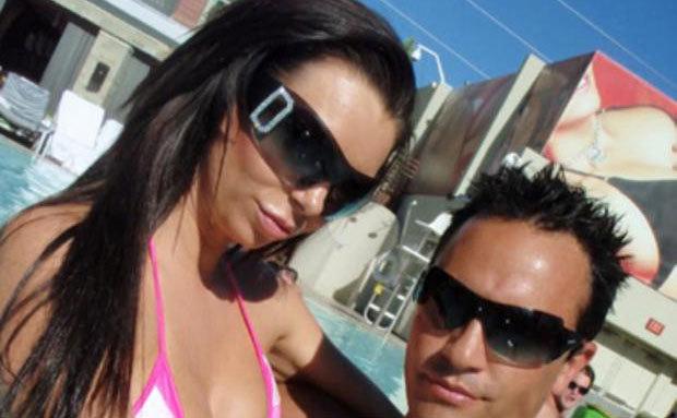 Fiore and Jenkins take a picture by a swimming pool.