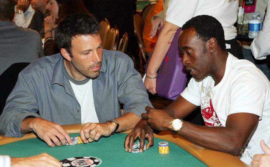 Ben Affleck and Don Cheadle talk as they participate in a poker game.