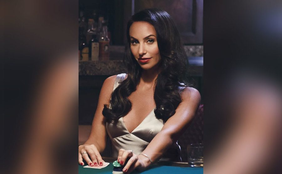 olly poses at a poker table.