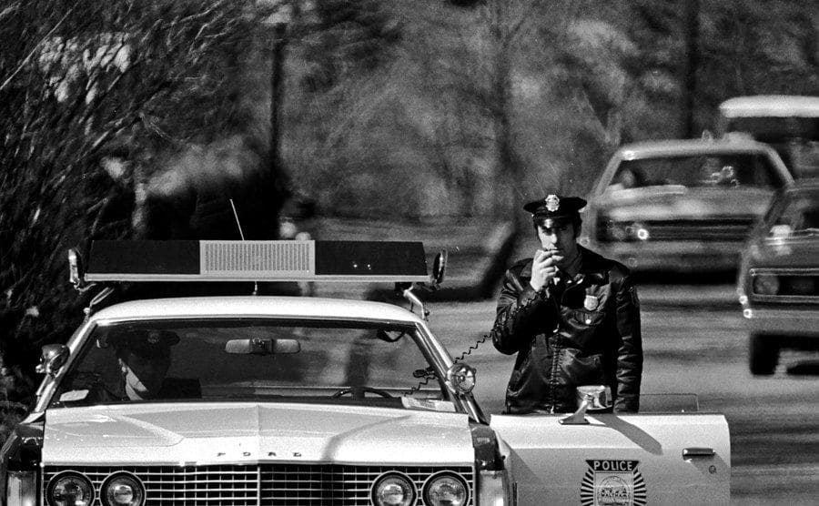 An image of a police officer using a cruiser radio.