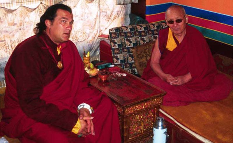 Steven Seagal sits with a Tibetan Monk.
