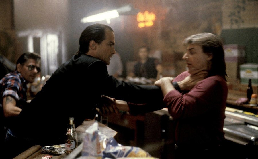 Steaven Seagal reaches across the bar to strangle a man in a still from the film.