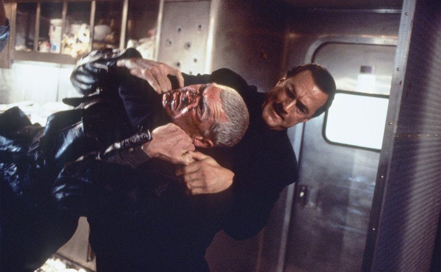 Seagal is fighting another man in a still from a film.