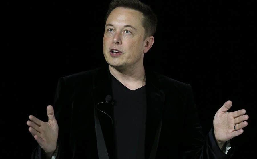 A picture of Musk speaking to the media.