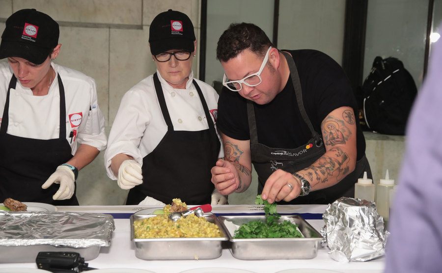 Graham Elliot plates dishes at an event.