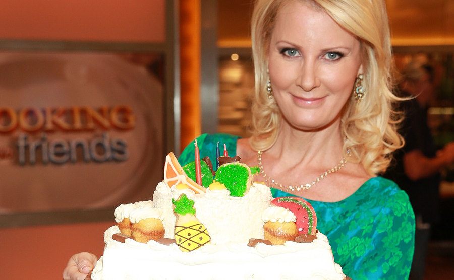 Sandra Lee holds a cake as she poses for the press.