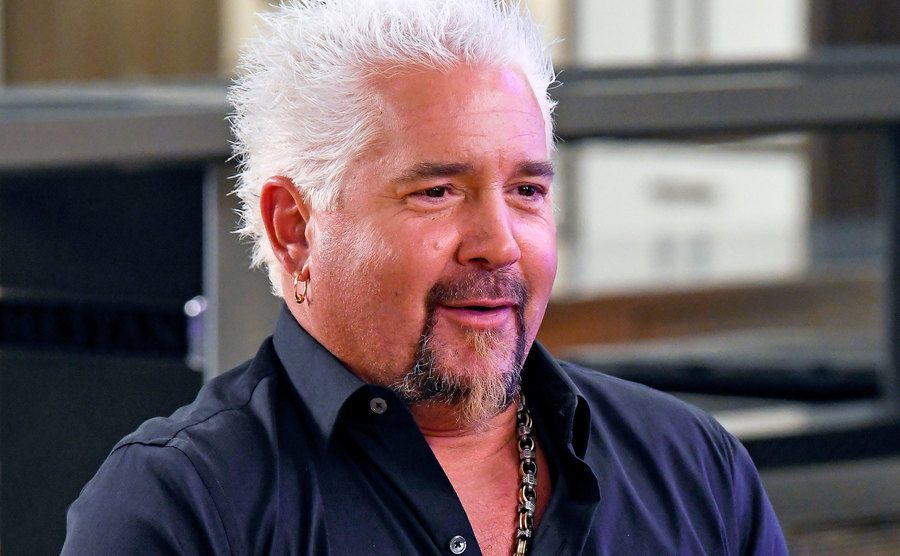 An image of Guy Fieri speaking at his restaurant.