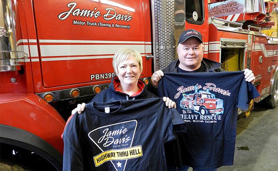 Jamie Davis stands holding a t-shirt that reads Jamie Davis.