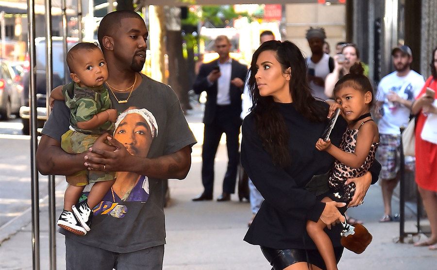 Kim Kardashian, Kanye West with North West and Saint West walk down the street.