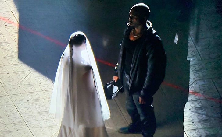 Kanye talks to Kim at the Donda event.