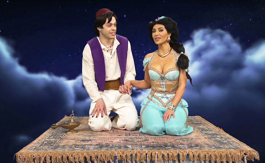 Pete Davidson and Kim Kardashian are riding a magic carpet and Alladdin and Jasmin.