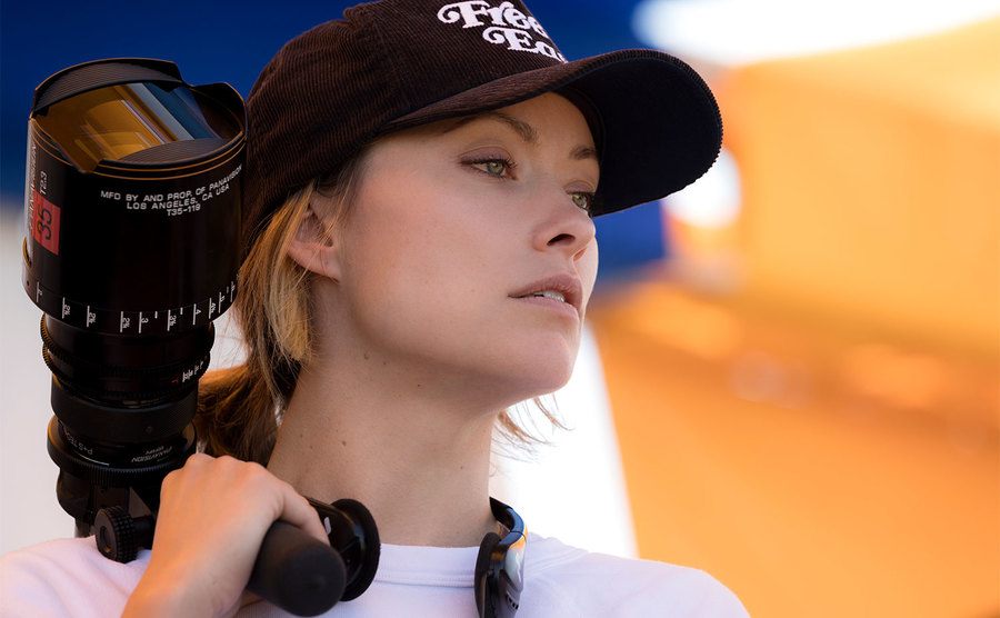 Olivia Wilde holds a lense on set.