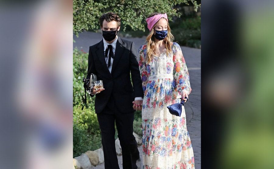 Olivia and Harry arrive at a wedding together.