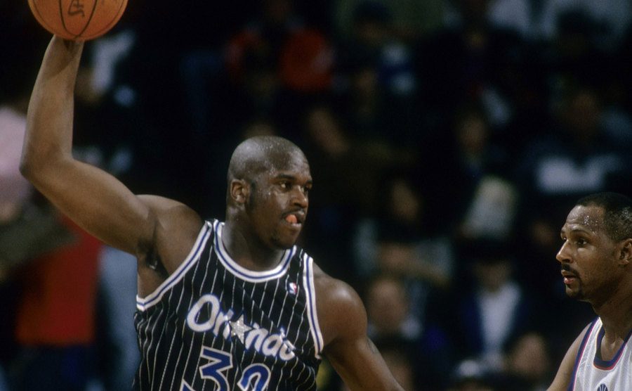 A photo of O’Neal being guarded by Kevin Duckworth.