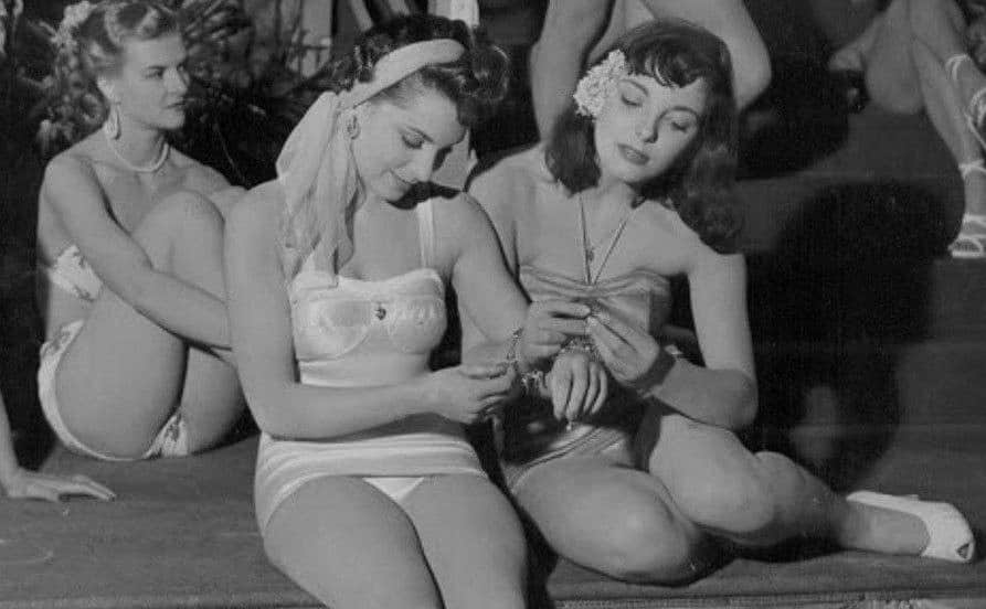 Joan Collins and another woman take a break on the set of Lady Godiva Rides Again.