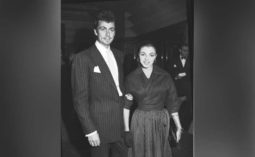 Reed poses beside Collins as he grabs onto her arm.