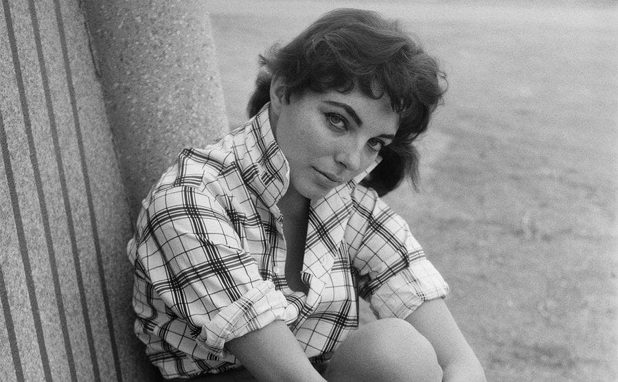 Joan Collins takes a break from filming at the studio to pose for a photograph.