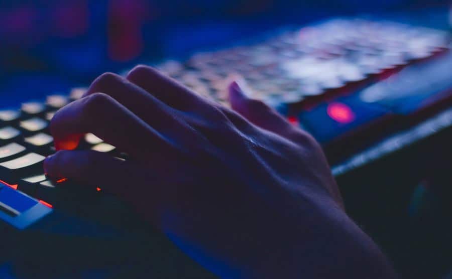 A young girl is typing on a keyboard.