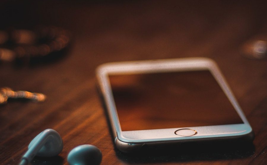 An image of a phone on a wooden desk.