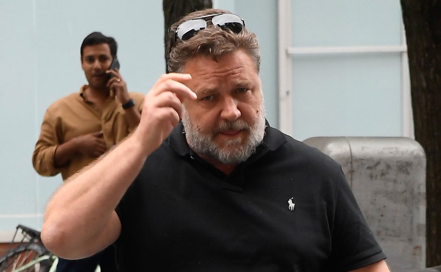 Russell Crowe walks the street.