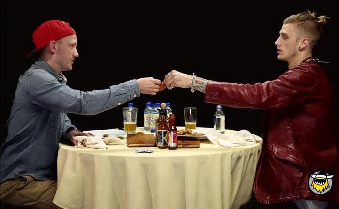 Sean Evens and Machine Gun Kelly toast before eating their spicy hot wings. 