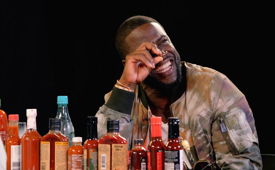 Kevin Hart wipes away a tear during his episode of Hot Ones. 