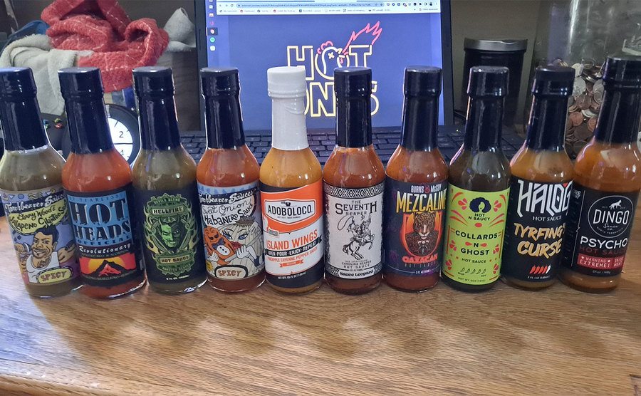 Different hot sauce bottles are placed on a table. 