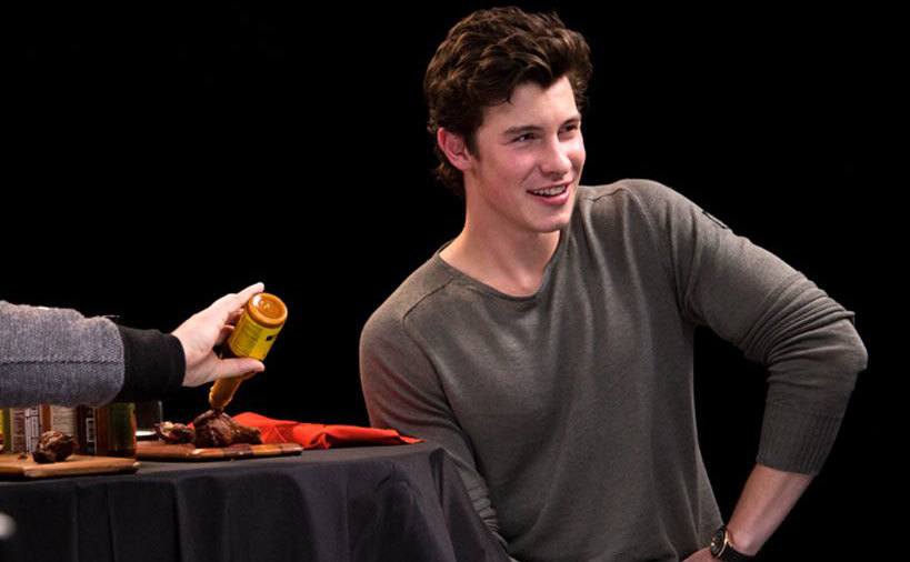 Shawn Mendes is preparing to taste a wing on an episode of Hot Wones. 