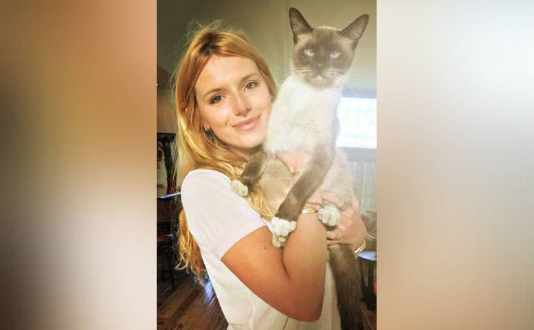 Bella poses for a photo with one of her cats.
