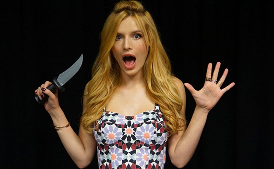 A scared looking Bella Thorne poses with a knife.